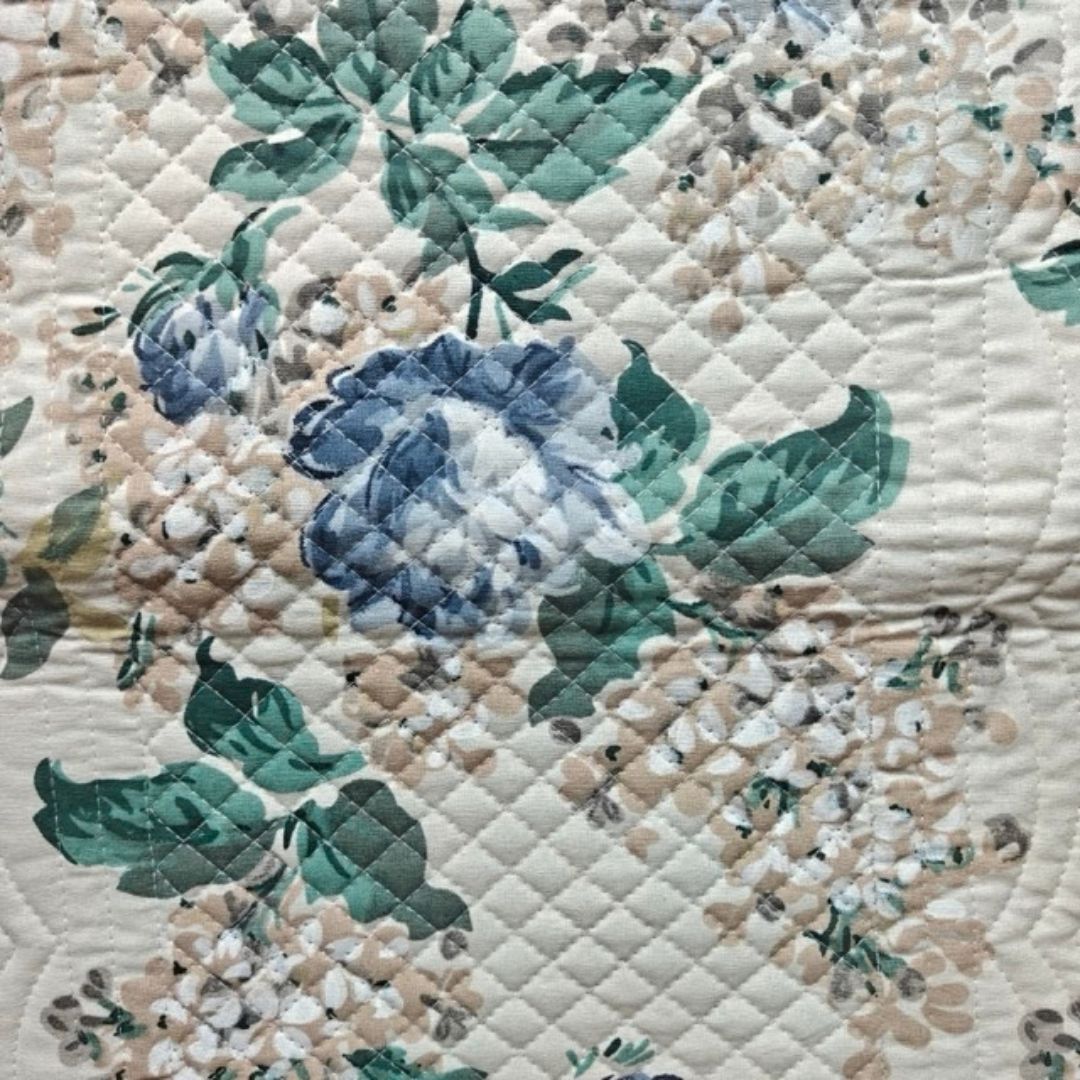 Close-up of blue hydrangea and green leaf print on quilted fabric